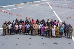 Participants of a ship tour aboard the Lewis B. Puller-class expeditionary sea base USS John L. Canley (ESB 6), pose for a group photo while the ship is moored in Luganville, Vanuatu, in support of Pacific Partnership 2025, Nov. 13.