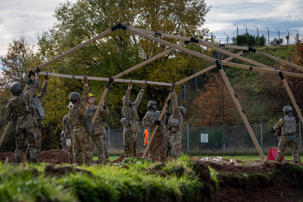 U.S. Air Force Airmen assigned to the 52nd Fighter Wing construct a tent during the first Airman Leadership School field training exercise at Spangdahlem Air Base, Germany, Nov. 6, 2025. The ALS field training exercise challenged students to operate in a simulated deployed environment. (U.S. Air Force photo by Airman 1st Class Sydney Franklin)
