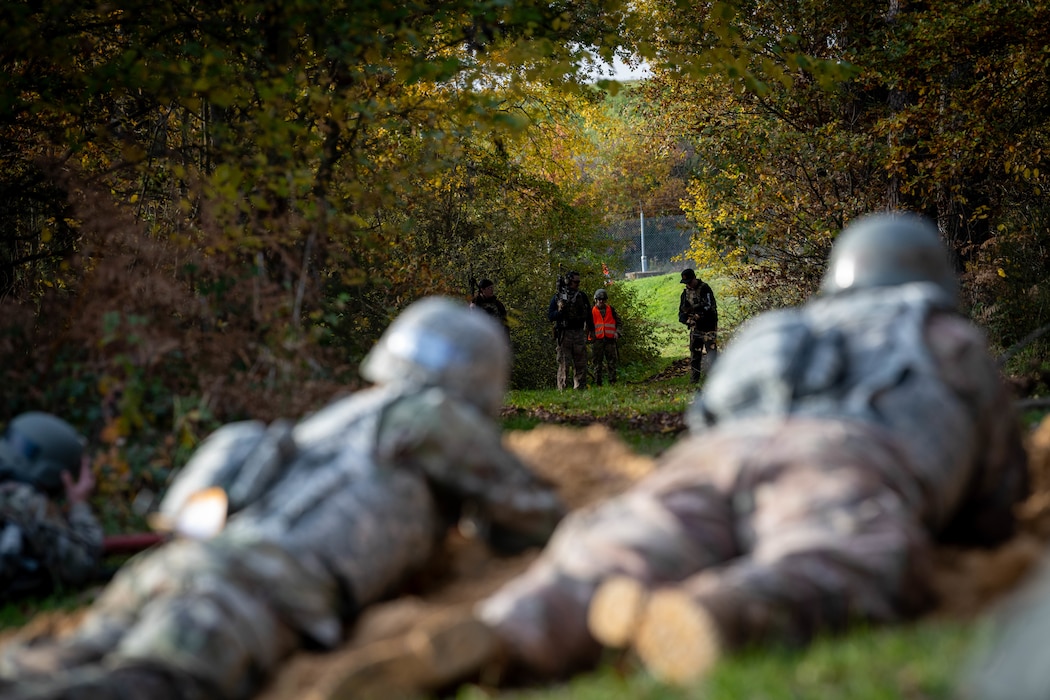 U.S. Air Force Airmen assigned to the 52nd Fighter Wing observe opposing forces during the first Airman Leadership School field training exercise at Spangdahlem Air Base, Germany, Nov. 6, 2025. The training helped Airmen practice staying alert and making quick decisions while working as a team. (U.S. Air Force photo by Airman 1st Class Sydney Franklin)