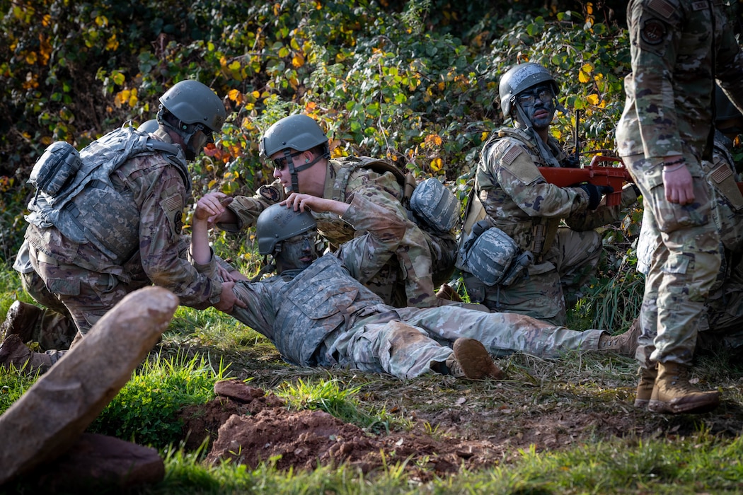 U.S. Air Force Airmen assigned to the 52nd Fighter Wing perform a simulated casualty evacuation during the first Airman Leadership School field training exercise at Spangdahlem Air Base, Germany, Nov. 6, 2025. The exercise placed Airmen in high-stress scenarios designed to strengthen team cohesion, communication and rapid decision making. (U.S. Air Force photo by Airman 1st Class Sydney Franklin)