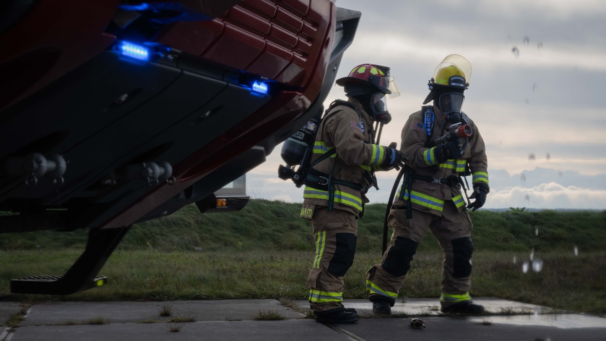 U.S. Air Force Staff Sgt. Blake Smith, left, 52nd Civil Engineer Squadron Fire and Emergency Services firefighter, and Airman 1st Class Juellz Stribling, 52nd Civil Engineer Squadron Fire and Emergency Services firefighter, prepare to douse a fire during a Prime Base Emergency Engineer Force (BEEF) training at Spangdahlem Air Base, Germany, Nov. 20, 2025. This training ensures our civil engineers maintain the rapid-response skills needed to support contingency operations and protect critical infrastructure across the wing. (U.S. Air Force photo by Senior Airman Darius Frazier)
