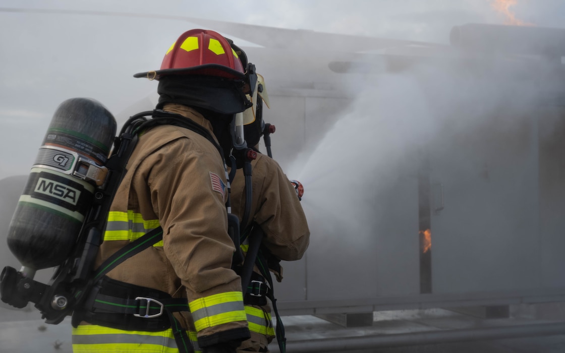 U.S. Air Force Staff Sgt. Blake Smith, left, 52nd Civil Engineer Squadron Fire and Emergency Services firefighter, and Airman 1st Class Juellz Stribling, 52nd Civil Engineer Squadron Fire and Emergency Services firefighter, extinguish a controlled fire during a Prime Base Emergency Engineer Force (Prime BEEF) training at Spangdahlem Air Base, Germany, Nov. 20, 2025. Realistic response scenarios prepares the firefighters for a wide range of potential emergencies at home and abroad.  (U.S. Air Force photo by Senior Airman Darius Frazier)
