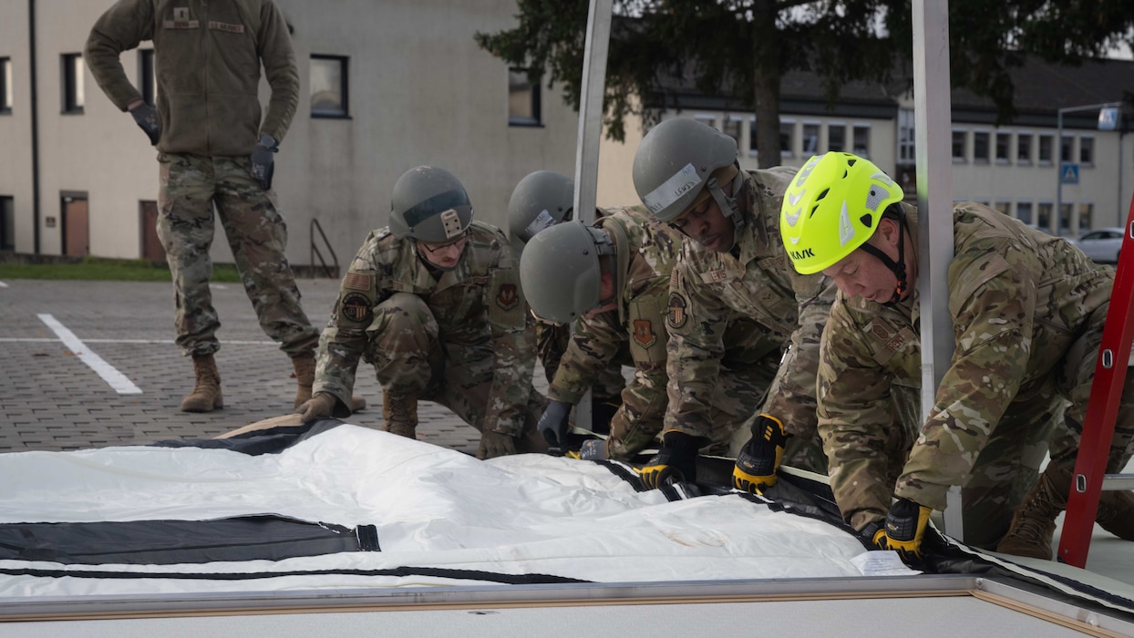 U.S. Air Force Airmen assigned to the 52nd Fighter Wing work together to assemble a small shelter system during a Prime Base Emergency Engineer Force (BEEF) training at Spangdahlem Air Base, Germany, Nov. 20, 2025. This training prepares the Airmen to quickly establish essential infrastructure in contingency environments. (U.S. Air Force photo by Senior Airman Darius Frazier)