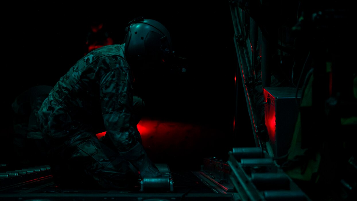 Master Sgt. Leon Bardwell, 75th Expeditionary Airlift Squadron loadmaster, positions a roller track for cargo