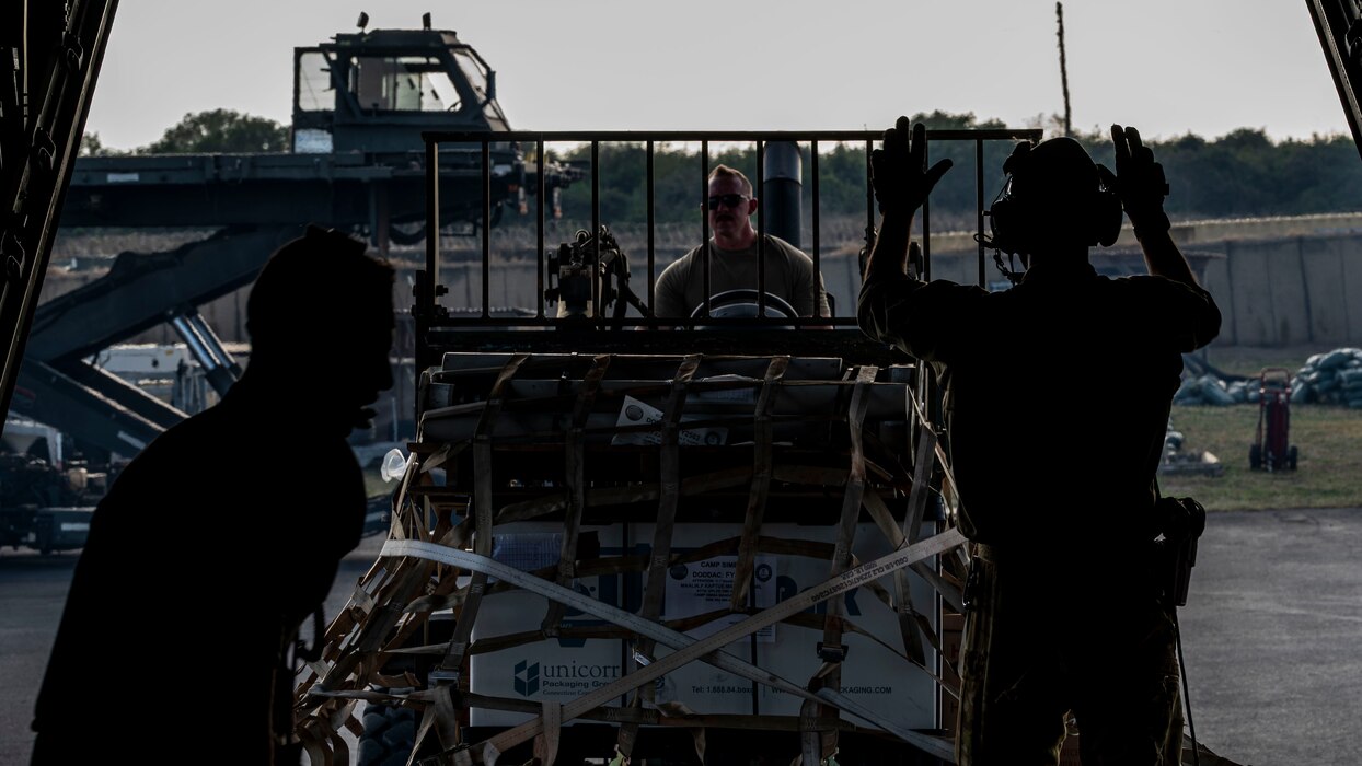 Staff Sgt. Tyler Zinke drives a forklift carrying cargo