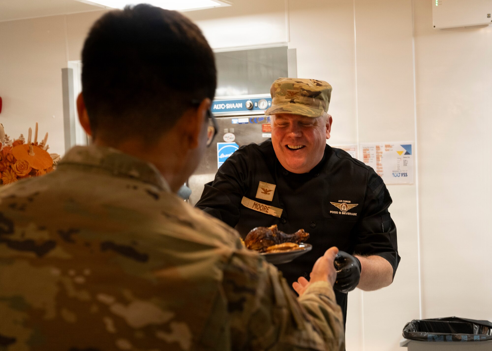 Col. Adam Moore, 352nd Special Operations Wing commander, serves food to Airmen at RAF Mildenhall, Nov. 26, 2025. The 100th Force Support Squadron and base leadership prepared and served meals to Airmen who are stationed away from home this holiday season. (U.S. Air Force photo by Staff Sgt. Nash Truitt)