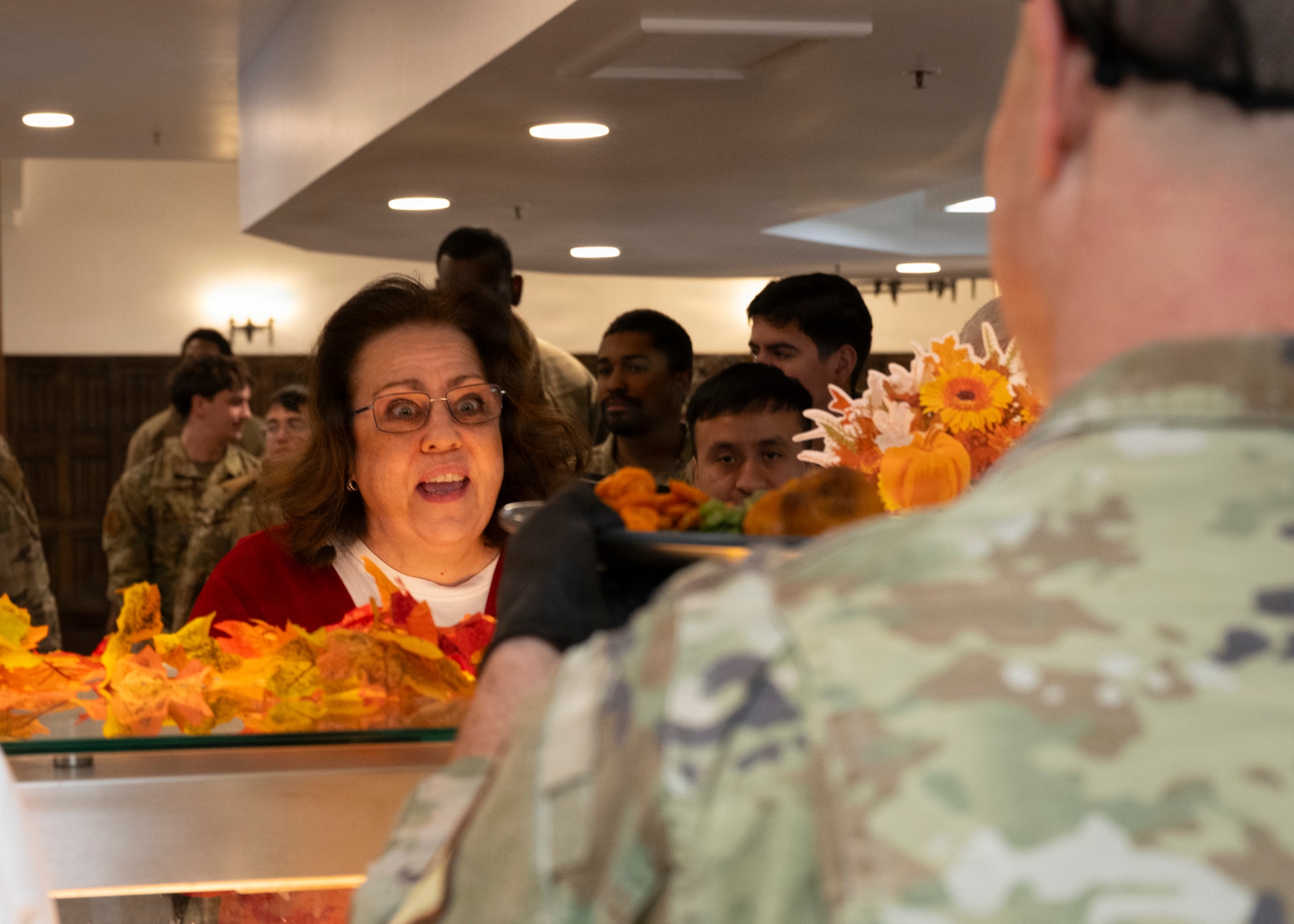 Karla Gurr 100th Air Refueling Wing military relations missionary, receives food from base leadership at RAF Mildenhall, Nov. 26, 2025. The 100th Force Support Squadron and base leadership prepared and served meals to Airmen who are stationed away from home this holiday season. (U.S. Air Force photo by Staff Sgt. Nash Truitt)