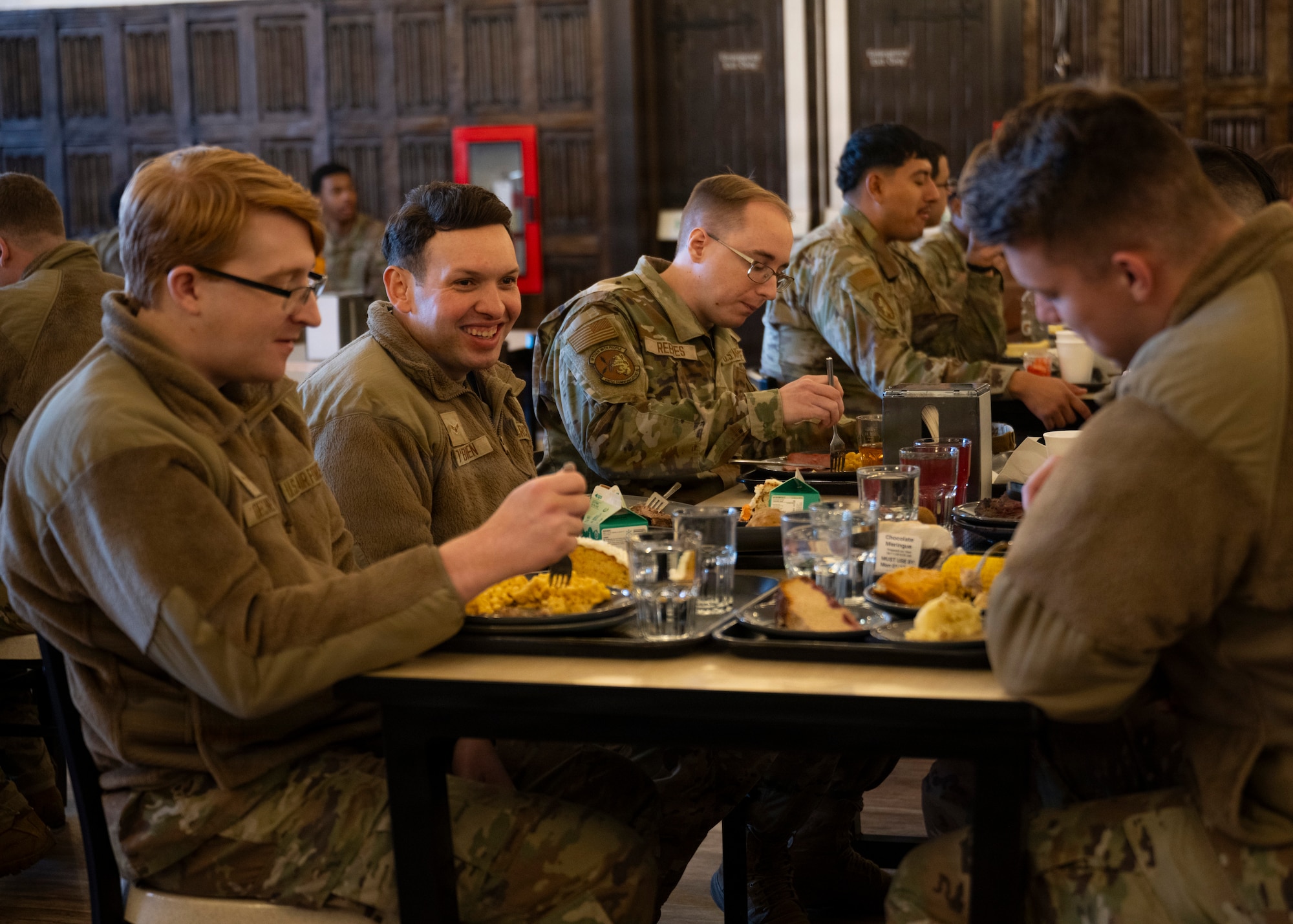 U.S. Air Force service members enjoy a Thanksgiving lunch served by base leadership at RAF Mildenhall, Nov. 26, 2025. The 100th Force Support Squadron and base leadership prepared and served meals to Airmen who are stationed away from home this holiday season. (U.S. Air Force photo by Staff Sgt. Nash Truitt)