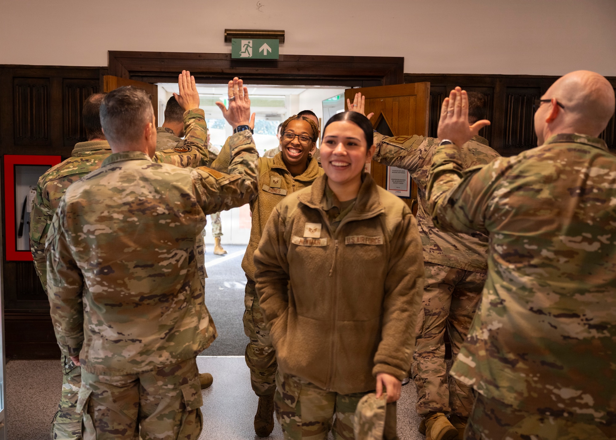 U.S. Air Force service members are greeted by 100th Air Refueling Wing first sergeants as they make their way to a Thanksgiving lunch at RAF Mildenhall, Nov. 26, 2025. The 100th Force Support Squadron and base leadership prepared and served meals to Airmen who are stationed away from home this holiday season. (U.S. Air Force photo by Staff Sgt. Nash Truitt)