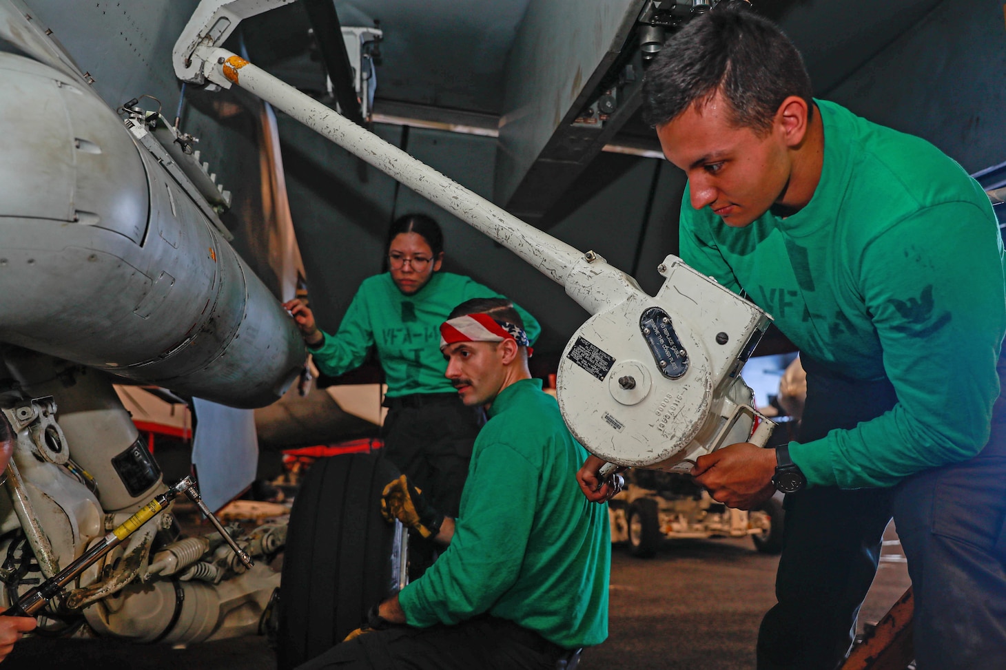 Sailors assigned to the "Tophatters" of Strike Fighter Squadron (VFA) 14, install an advanced targeting forward looking infrared (ATFLIR) pod on an F/A-18E Super Hornet in the hangar bay aboard the Nimitz-class aircraft carrier USS Abraham Lincoln (CVN 72). Abraham Lincoln Strike Group is underway conducting routine operations in the U.S. 3rd Fleet.