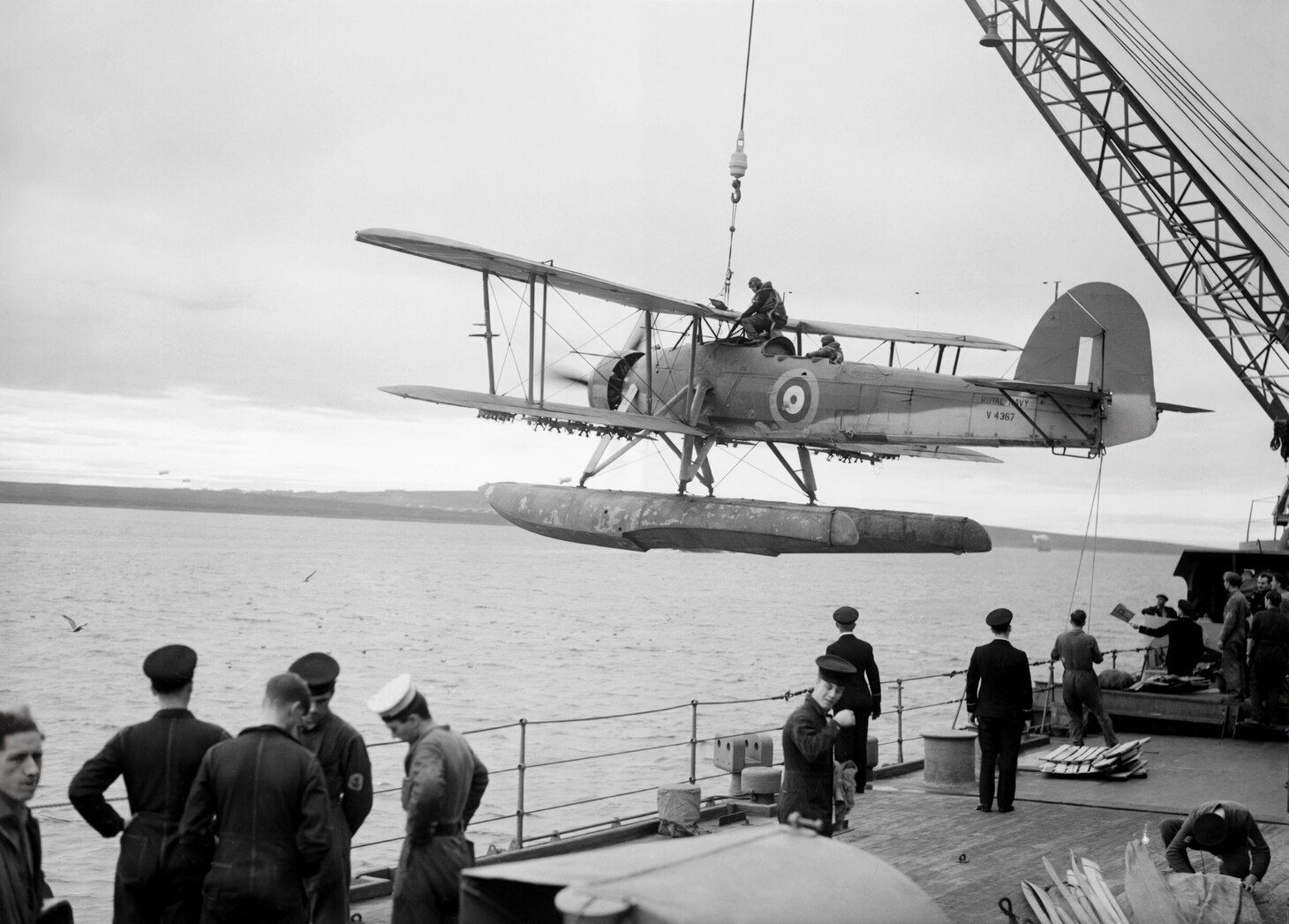 Flown also as a floatplane, this Swordfish of No. 700 Naval Air Squadron is craned aboard the Royal Navy battleship HMS Malaya in October 1941 during exercises. When the ship deployed a month later, a biplane seaplane Westland Walrus had replaced the Fairey torpedo-spotter-reconnaissance, mainly for rescue duties.
