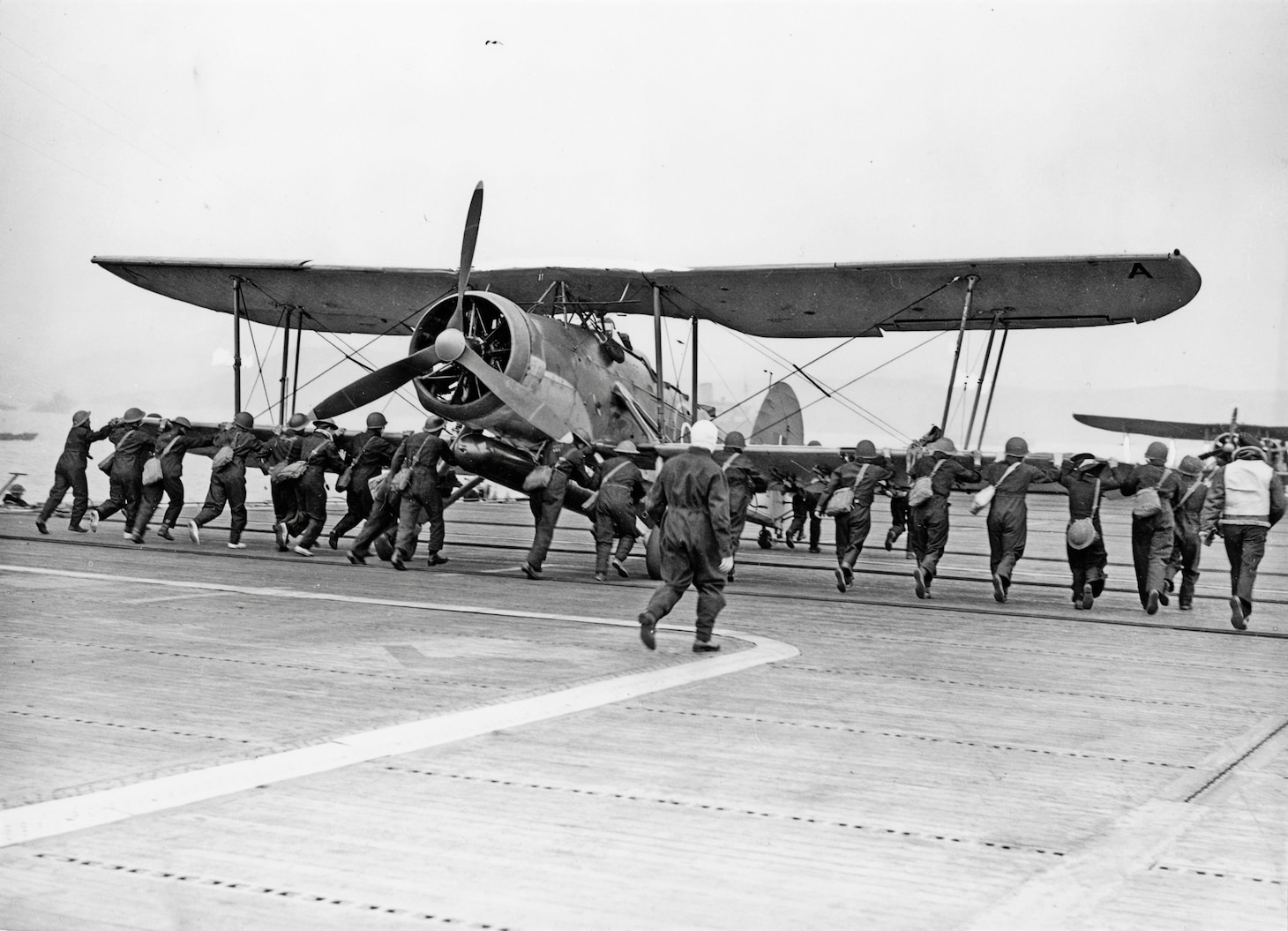 Before launching, a torpedo is loaded onto a Swordfish built by Blackburn aboard the escort carrier HMS Battler in April 1941.