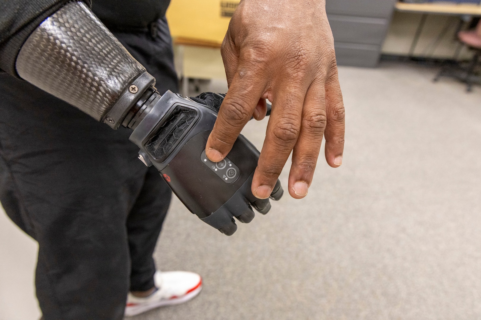 A clinical trial participant demonstrates different functions of a “neural-enabled” prosthetic arm at Walter Reed National Military Medical Center, Oct. 22. Walter Reed is taking part in a clinical trial for a next-generation device designed to restore the sensation of touch through advanced nerve stimulation technology. (DOW photo by Ann Brandstadter)