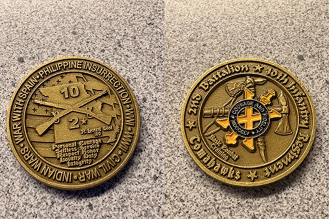 Two sides of a coin, one side has crossed muskets and the out like of the state of Missouri the other side has a yellow X and crossed tomahawks.