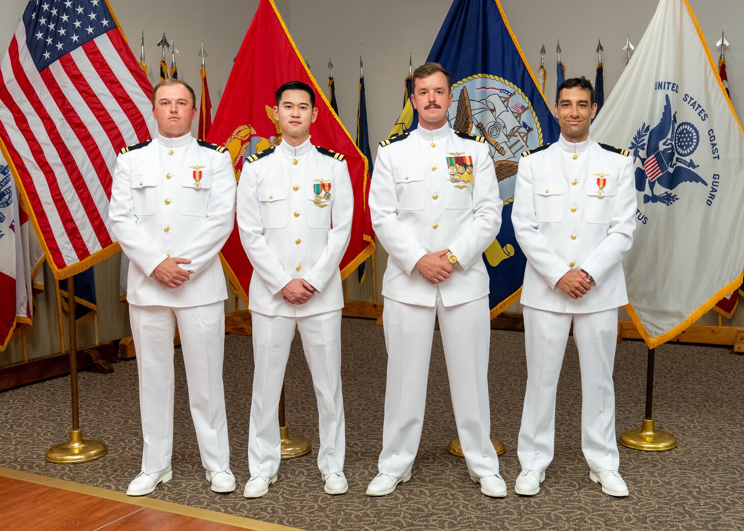 The first four newly winged naval aviators to graduate from the T-54A METS Program pose for a photo during their winging ceremony at Naval Air Station Corpus Christi, Sept. 5. The winging ceremony is a time-honored tradition where new naval aviators receive their Wings of Gold.