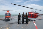 Capt. Travis Suggs, operations officer of Chief of Naval Air Training, left, and Cmdr. James Gelsinon, commanding officer of Helicopter Training Squadron (HT) 28, center, present a TH-57C Sea Ranger aviation log book to retired Capt. Steve Banta, executive director of the USS Lexington Museum on the Bay, as part of a ceremonial turnover after landing the aircraft on decommissioned aircraft carrier USS Lexington (CV 16) Museum on the Bay. This landing commemorates the legacy of the TH-57 training helicopter while showcasing the future of naval aviation with the TH-73.