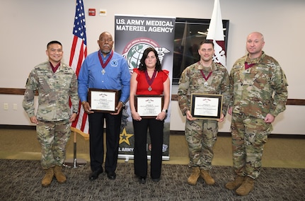 Leaders at the U.S. Army Medical Materiel Agency inducted three new members into the Order of Military Medical Merit, or O2M3, during an awards ceremony Nov. 20 at Fort Detrick, Md. Flanked by USAMMA Commander Col. Joselito “Joe” Lim and Sgt. Maj. Todd Brenecki are, from left, Claudie Shelton, Cheryl Alligood and Chief Warrant Officer 3 Richard Hendricks.
