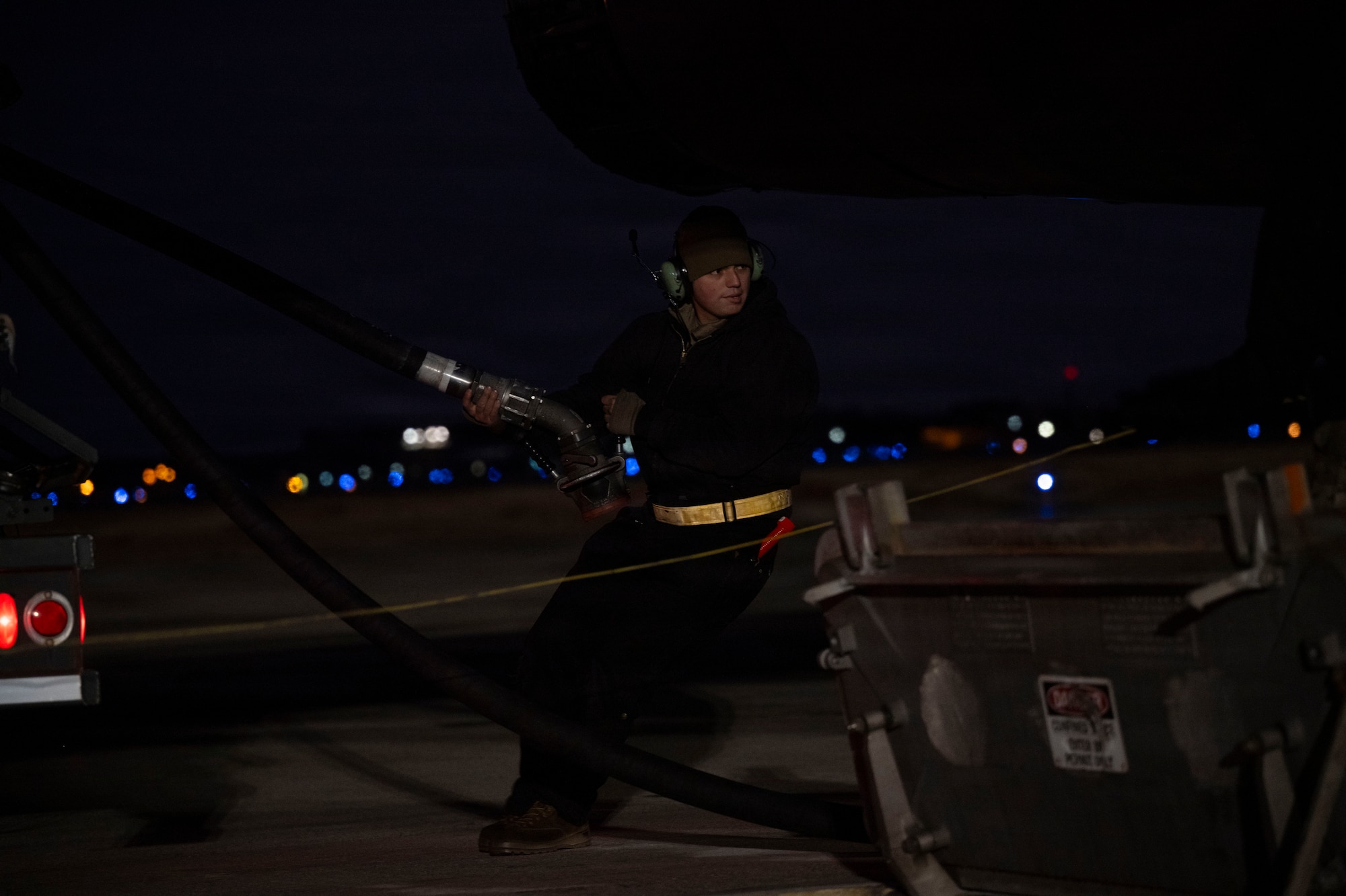 U.S. Air Force Senior Airman Henry Uriarte, 9th Expeditionary Bomb Squadron crew chief, hot pit refuels a B-1B Lancer before its return to Dyess Air Force Base, Texas, at Misawa Air Base, Japan, Nov. 15, 2025. Hot pit refueling leads to faster and more agile operations by allowing the aircraft to refuel without stopping their engines. (U.S. Air Force photo by Senior Airman Emma Anderson)