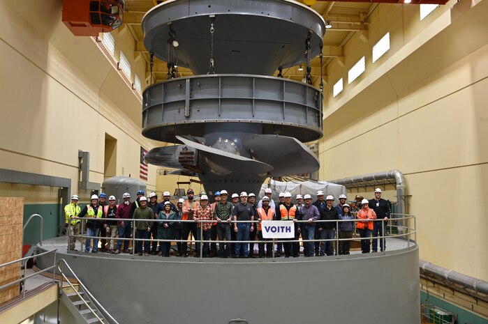 A group of USACE and Voith employees celebrate in front of the newly assembled turbine unit 1 at Ice Harbor Lock and Dam, near Burbank, Wash.