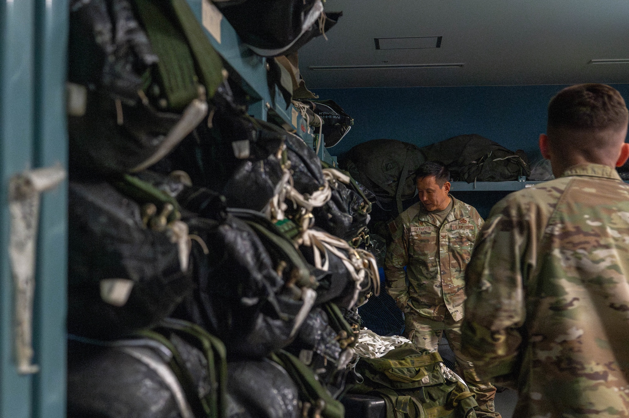 U.S. Air Force Col. Burt Okamoto, 374th Mission Support Group commander, tours the parachute stock area.