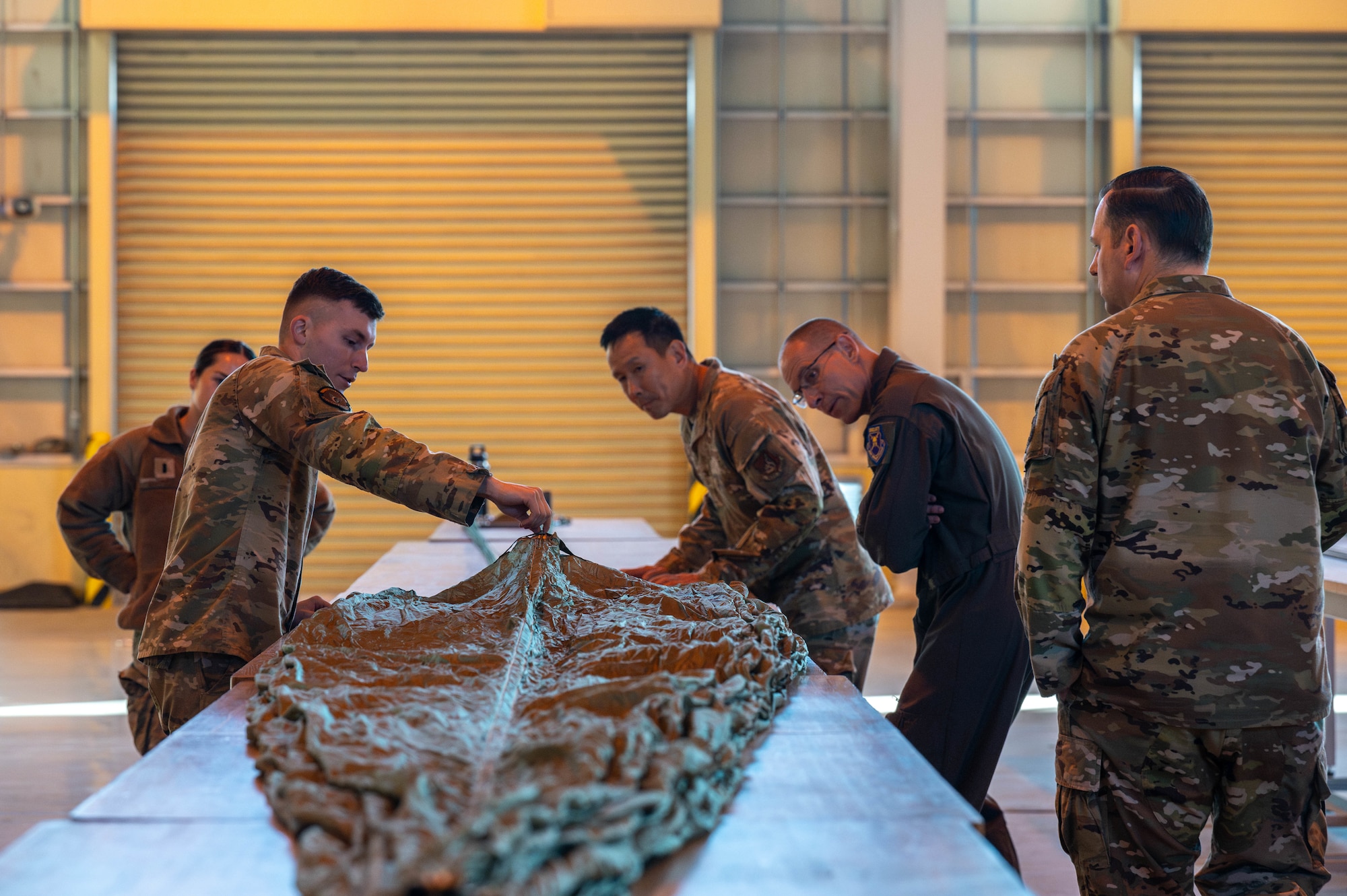 U.S. Air Force Senior Airman Gabriel Bundrick, 374th Logistics Readiness Squadron combat mobility flight combat mobility technician, left, holds a parachute rigging demonstration.