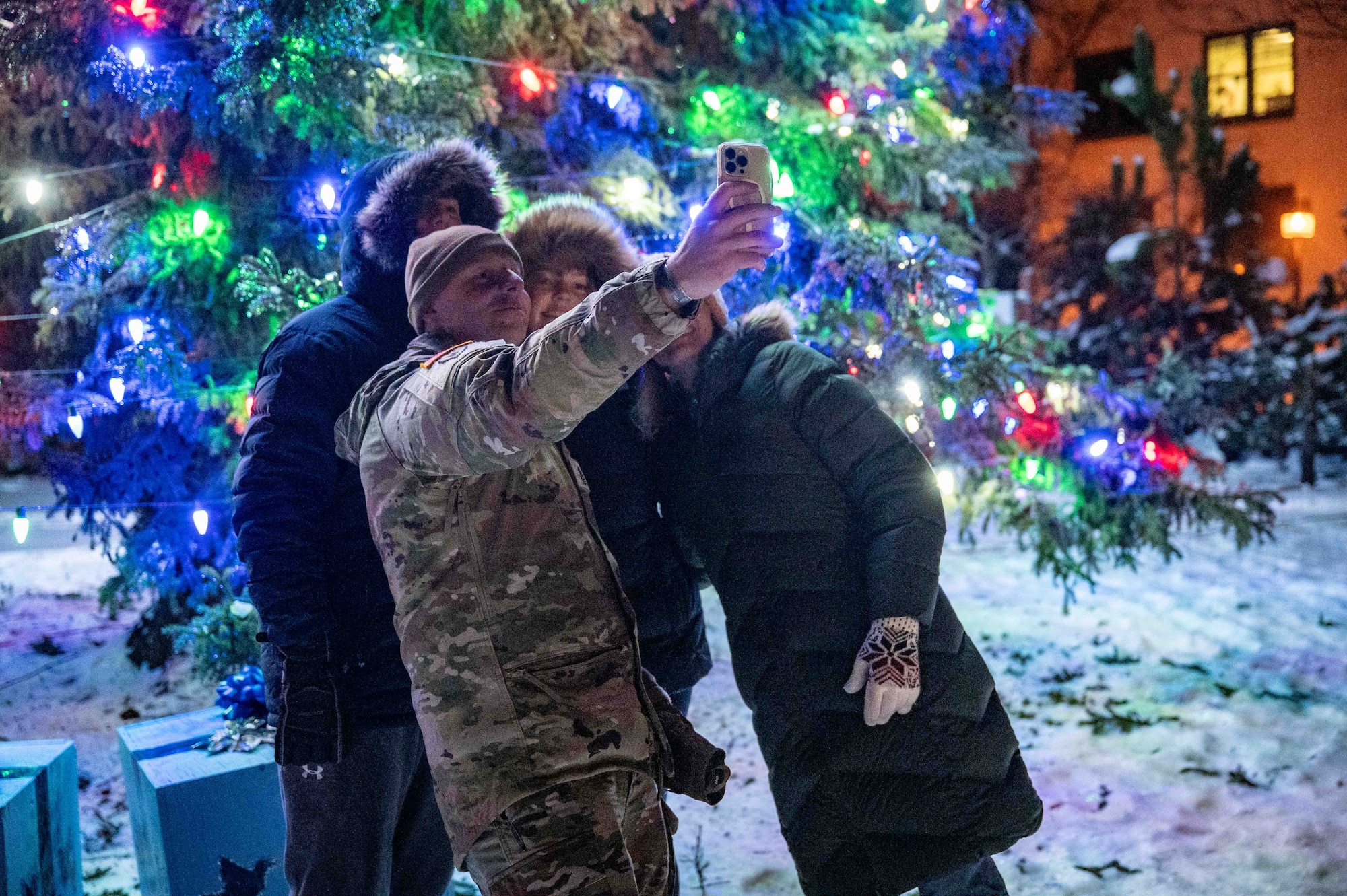 U.S. Army Sgt. Maj. Joshua McComas, the Joint Base Elmendorf-Richardson and 673d Air Base Wing sergeant major, poses with attendees during the annual tree lighting ceremony at Joint Base Elmendorf-Richardson, Alaska, Dec. 2, 2025. The 773d Force Support Squadron hosts the ceremony annually to promote  community readiness and cohesion during the festive season. (U.S. Air Force photo by Senior Airman Hunter Hites)