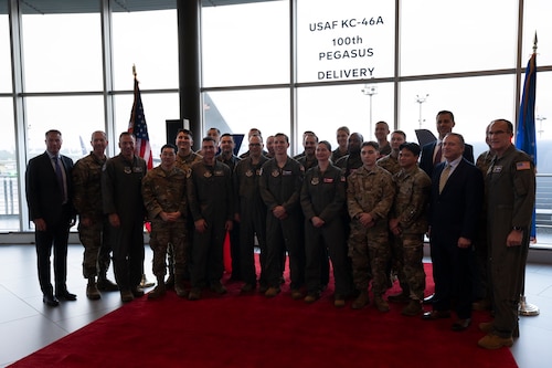 Airmen, industry and mission partners pose for a photo during the KC-46A Tanker 100th Delivery Ceremony, Dec. 2, 2025, at the Everett Delivery Center in Everett, Washington. The KC-46A Pegasus is an aerial refueling aircraft capable of performing single and multi-point simultaneous aerial refueling. Designed for versatility and survivability, the aircraft can also support passenger and cargo movement, aeromedical evacuation, and features defensive, self-protection, and communication systems suited for contested environments. (U.S. Air Force photo by Staff Sgt. Dalton Williams)