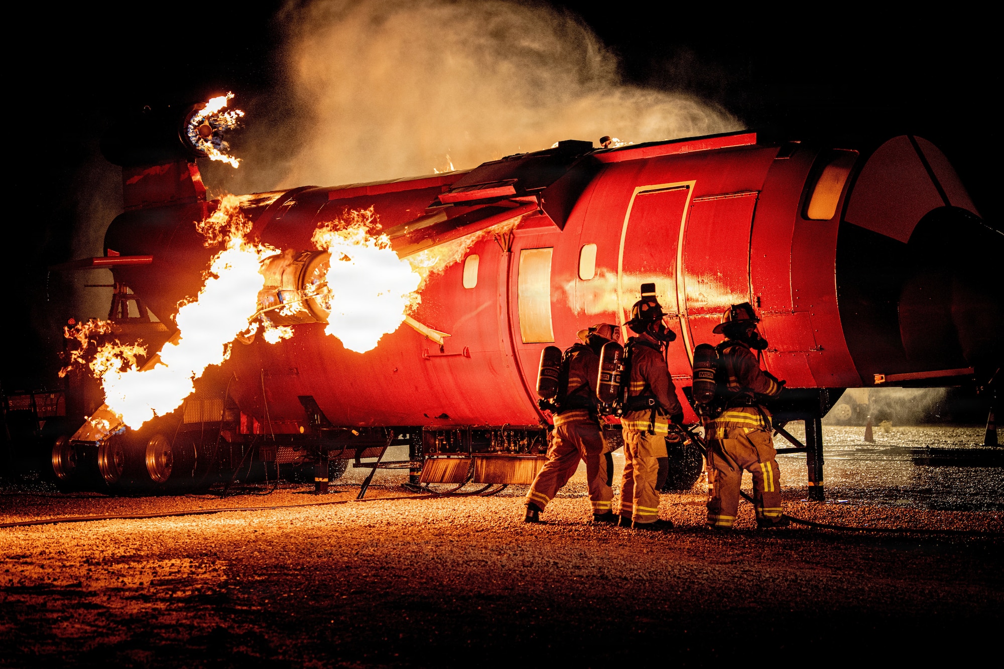Edwards Air Force Base firefighters work together to put out a fire during an aircraft live fire training event at Edwards Air Force Base, California, Nov 5., 2025. Firefighters are expected to know how to use various equipment to include water hoses, extinguishers, and personal protective equipment to include gloves, helmets, hoods, masks, etc. (U.S. Air Force photo by 1st Lt. Danielle Rose)