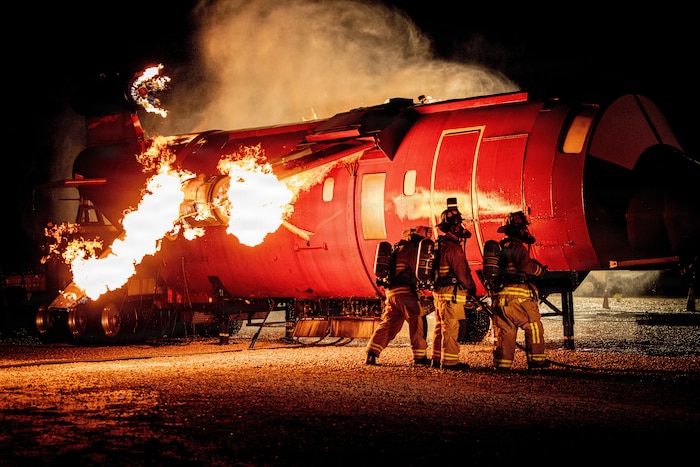 Edwards Air Force Base firefighters work together to put out a fire during an aircraft live fire training event at Edwards Air Force Base, California, Nov 5., 2025. Firefighters are expected to know how to use various equipment to include water hoses, extinguishers, and personal protective equipment to include gloves, helmets, hoods, masks, etc. (U.S. Air Force photo by 1st Lt. Danielle Rose)