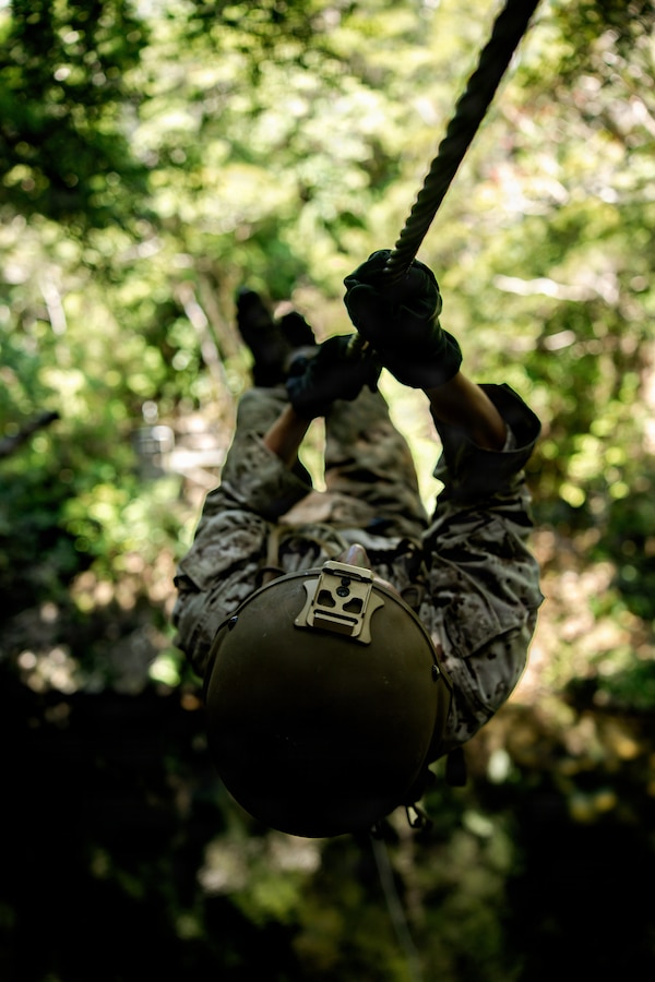 U.S. Marine Corps Cpl. Brandon Aguilar, a native of California and a satellite communications operator maintainer with 7th Communication Battalion, III Marine Expeditionary Force Information Group, crosses a rope line on an obstacle course during Operation Odyssey Stormbreaker III at Jungle Warfare Training Center, Okinawa, Japan, Nov. 4, 2025.