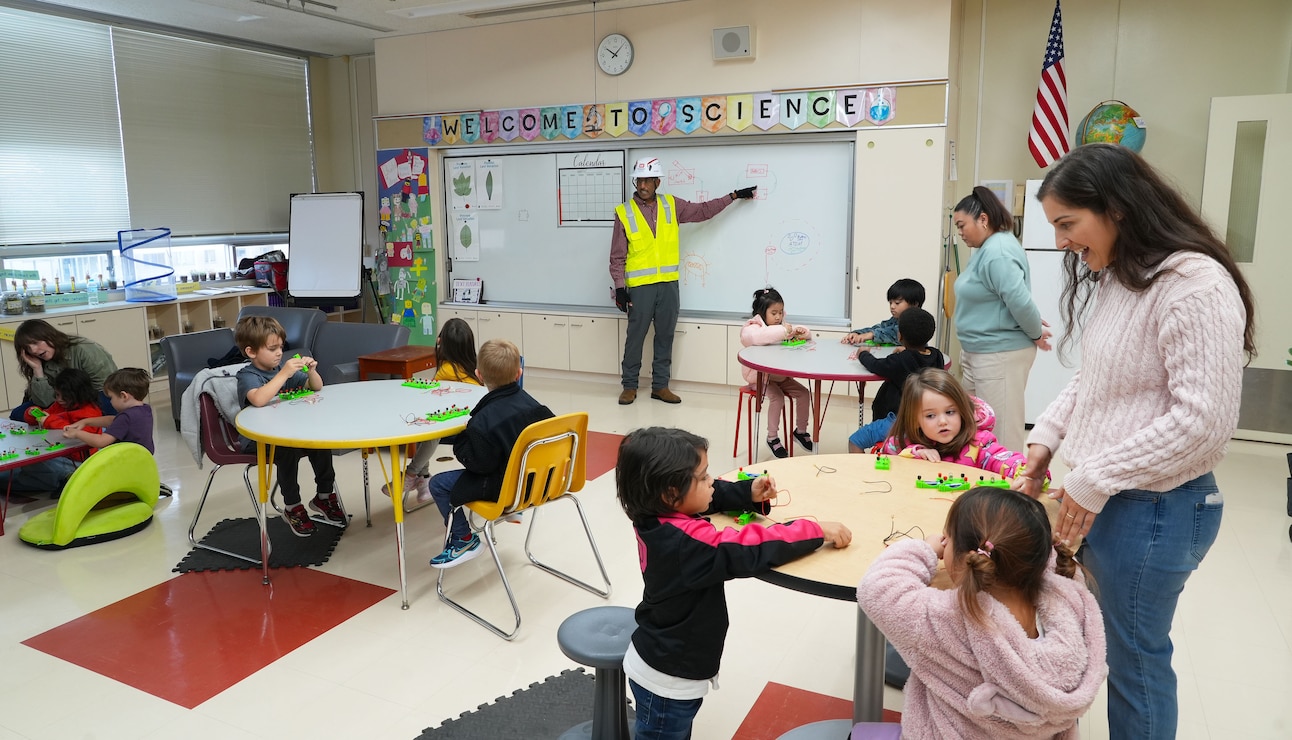 U.S. Army Corps of Engineers Japan District (USACE JED) engineering division civil engineer, Joseph Dashiell, center, explains the science behind building electrical circuits to students from Naval Air Facility Atsugi’s Shirley Lanham Elementary School during their annual Science Technology Engineering Art and Mathematics (STEAM) Day event, December 3rd, 2025. Dashiell, a civil engineer with the District’s engineering division, explained how electrical systems support USACE’s work in Japan and encouraged the children to troubleshoot, communicate, and think critically, which are key skills engineers rely on every day. Photo by Patrick Ciccarone.