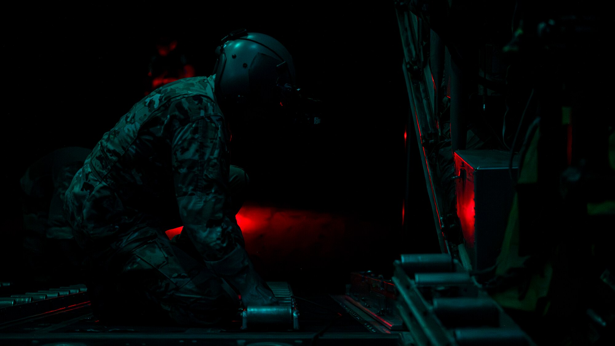 Master Sgt. Leon Bardwell, 75th Expeditionary Airlift Squadron loadmaster, positions a roller track for cargo