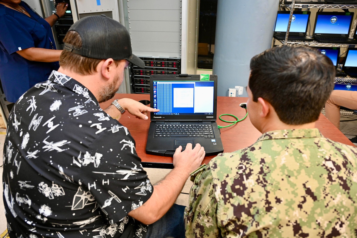 Navy personnel discussing network systems and configurations