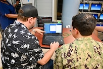 Navy personnel discussing network systems and configurations