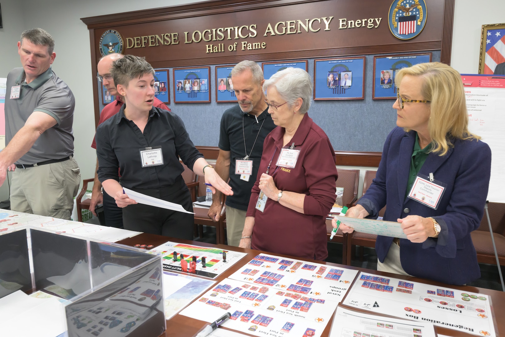 People standing in a group look at documents.
