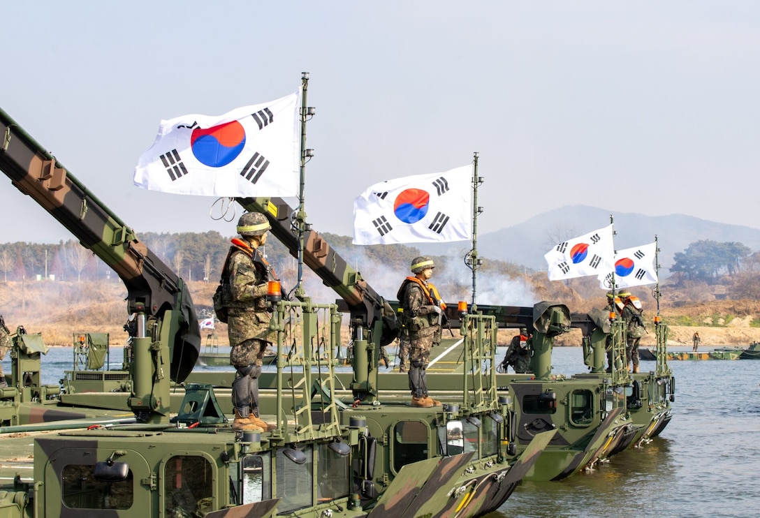 South Korean soldiers pull security on a M3 Bridge vehicle during a wet gap crossing exercise.