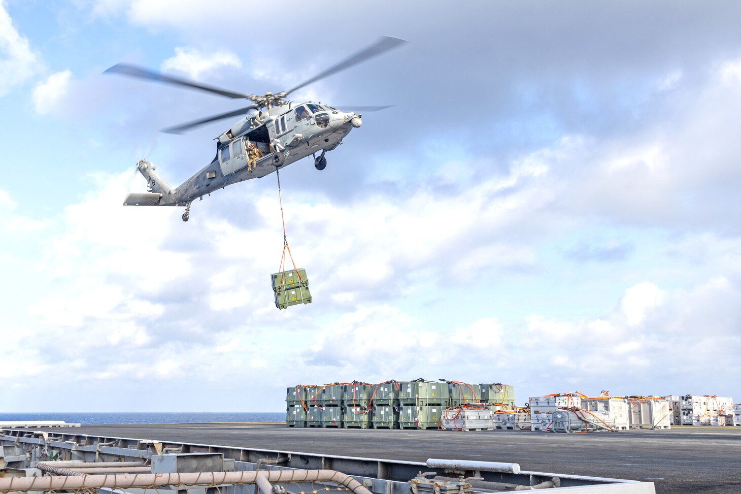 An MH-60S Seahawk helicopter, attached to the "Dragonslayers" of Helicopter Sea Combat Squadron (HSC) 11, transports ordnance from the flight deck of the Nimitz-class aircraft carrier USS Harry S. Truman (CVN 75) to the Lewis and Clark-class supply ship USNS Robert E. Peary (T-AKE 5) during an ammunition offload. Truman is currently underway in the Atlantic Ocean.