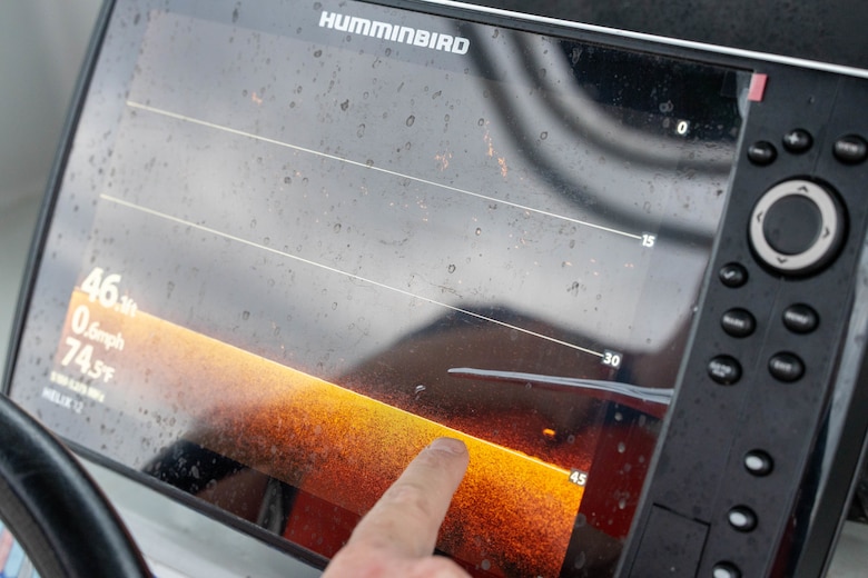 A hand points to a black screen with orange at the bottom of the screen.