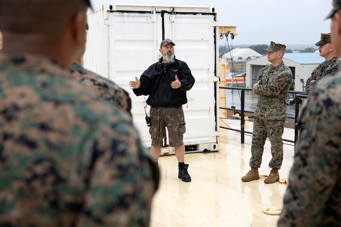 Jacob George, chief mate contractor for Crowley, contracted by the U.S. Navy's Military Sealift Command, explains ship capabilities and crew support aboard the USNS Sgt. William R. Button during a visit by a Marine expeditionary force liaison team Dec. 2, 2025, at Marine Corps Support Facility Blount Island, Florida. With 22 years of experience in the Merchant Marines, George has supported numerous military operations. (Official Marine Corps Photo by Dustin Senger)