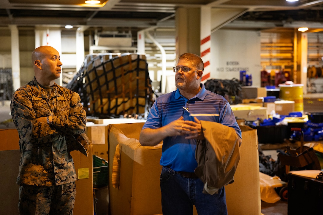 Robert Hazlett, contracting officer's technical representative for Blount Island Command, explains equipment and supply storage aboard the USNS Sgt. William R. Button during a visit by a Marine Expeditionary Force liaison team on Dec. 2, 2025, at Marine Corps Support Facility Blount Island, Florida. Hazlett, a Marine Corps veteran who served six years in motor transportation and nearly 20 years afloat as a KBR contractor—including six years as a squadron supervisor—became a sworn civilian at Blount Island in 2024. (Official Marine Corps Photo by Dustin Senger)