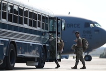 An Airman shows the shaka before boarding a bus after returning from the Joint Pacific Multinational Readiness Center rotation 26-01 exercise in Hawaii.