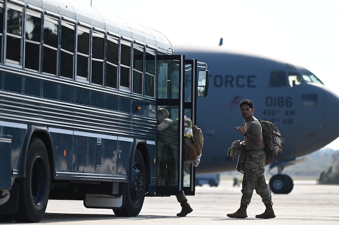 An Airman shows the shaka before boarding a bus after returning from the Joint Pacific Multinational Readiness Center rotation 26-01 exercise in Hawaii.