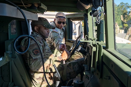U.S. Army Sgt. Kaleel Ivy, wheeled vehicle mechanic with the 1st Battalion, 204th Air Defense Artillery Regiment, Mississippi National Guard, instructs U.S. Air Force Airman 1st Class Joseph Frazier, 11th Civil Engineer Squadron structural journeyman, on basic operations of a Humvee at Fort Belvoir, Va., Oct. 16, 2025.