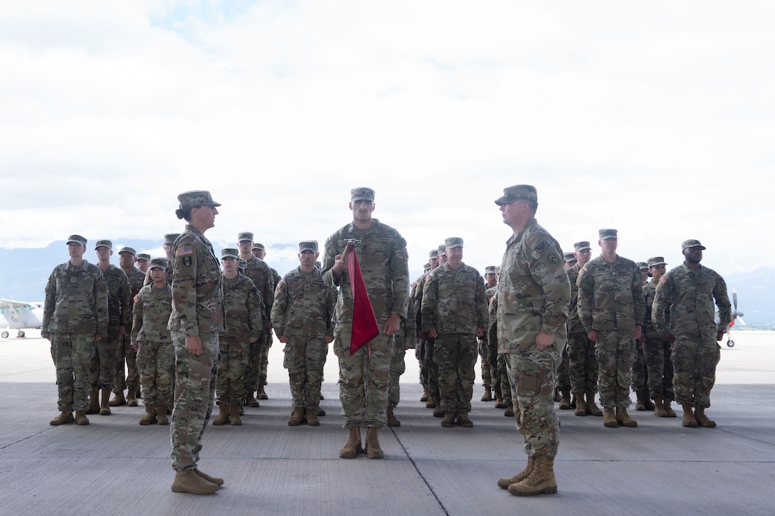 People in military uniforms stand in formation