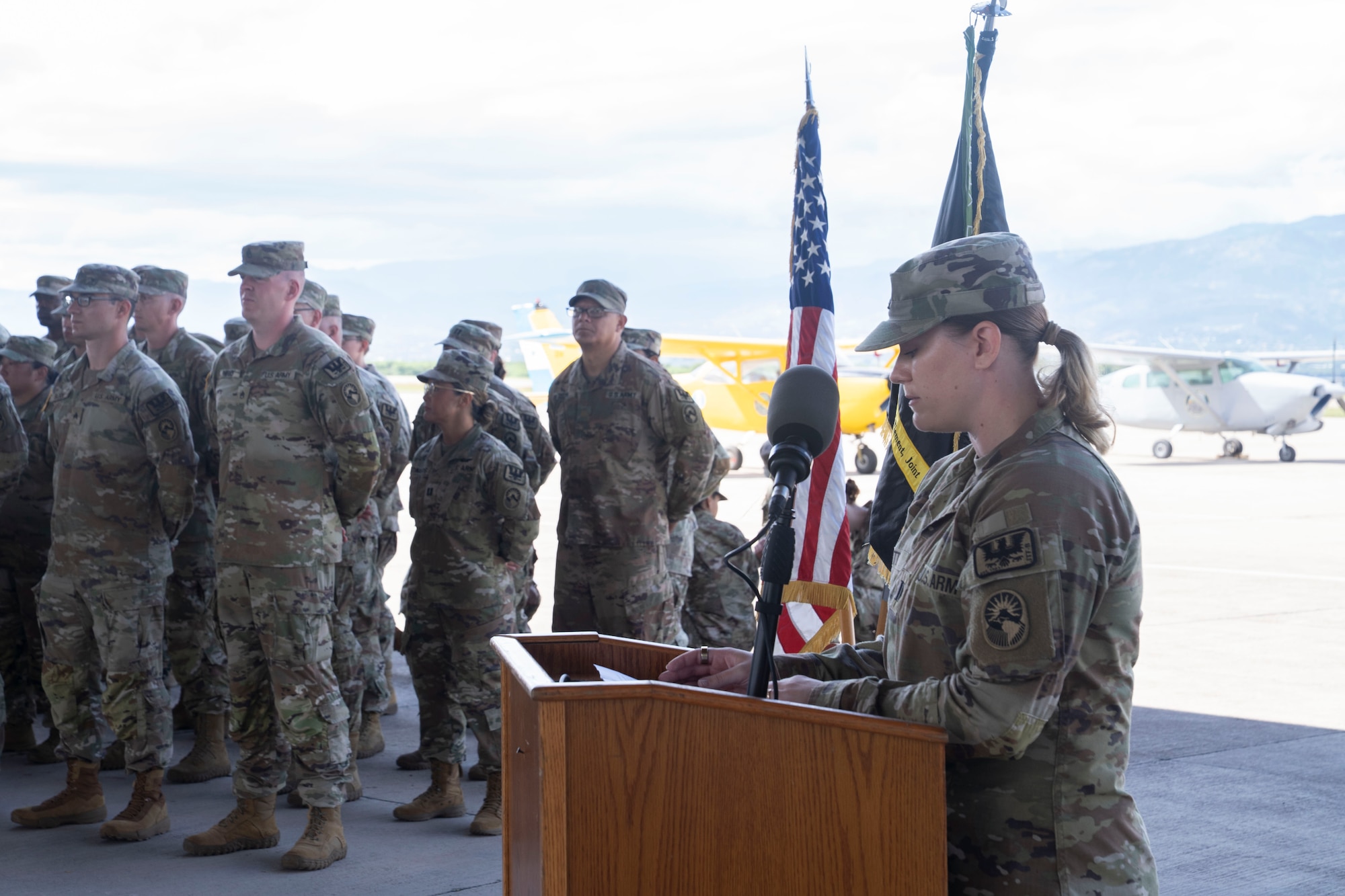 A person in military uniform speaks at a podium