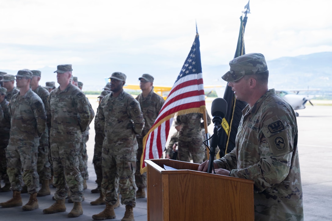 A person in military uniform speaks at a podium