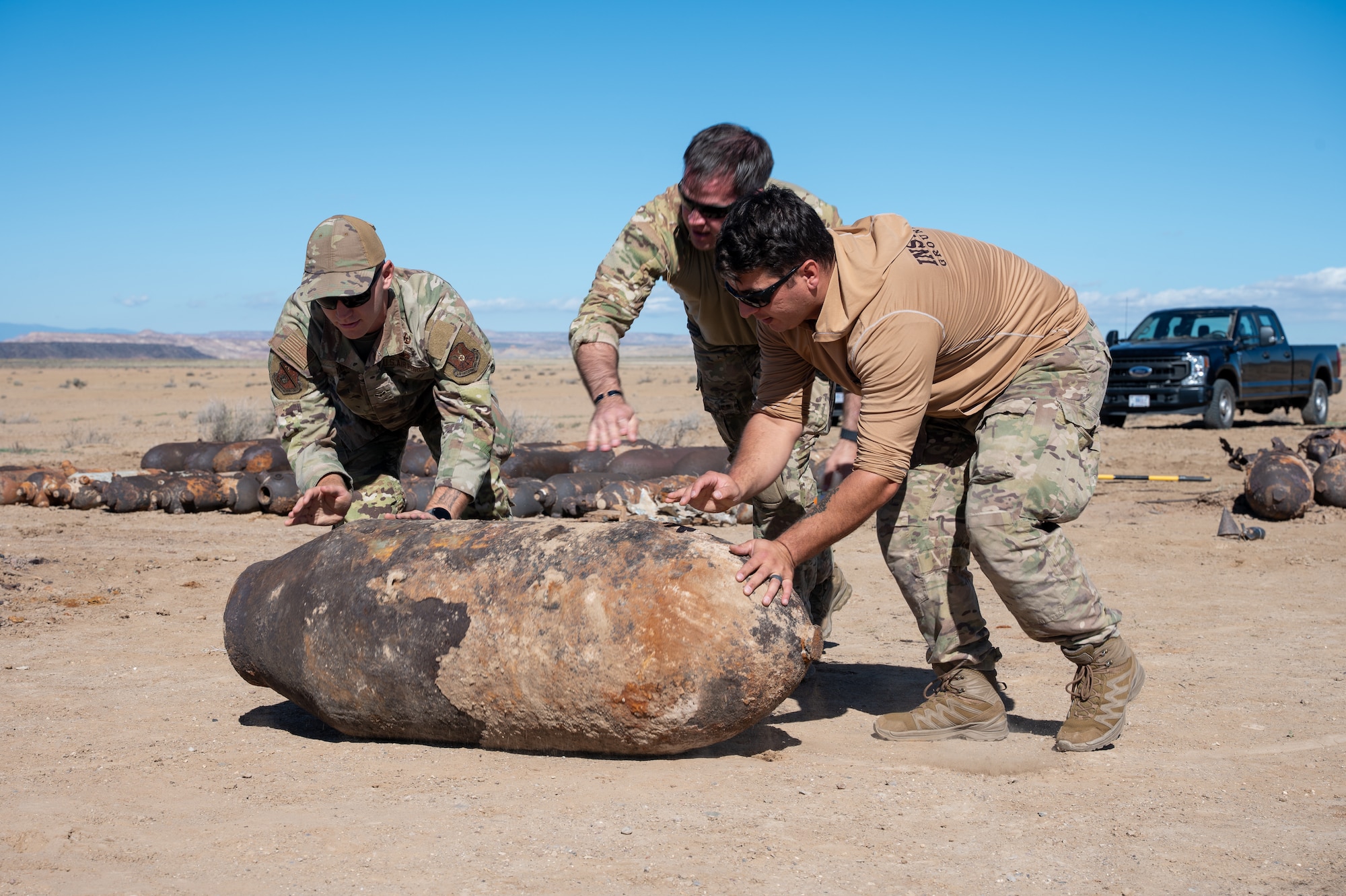 Airmen from the 377th Explosive Ordnance Disposal Flight maneuver a large piece of unexploded training ordnance during a clearance operation on the Isleta Pueblo, N.M., Oct. 16. The cleanup, conducted in partnership with tribal authorities, supports long-term land restoration and ensures the safety of community members. (U.S. Air Force photo by Senior Airman Donnell Schroeter)