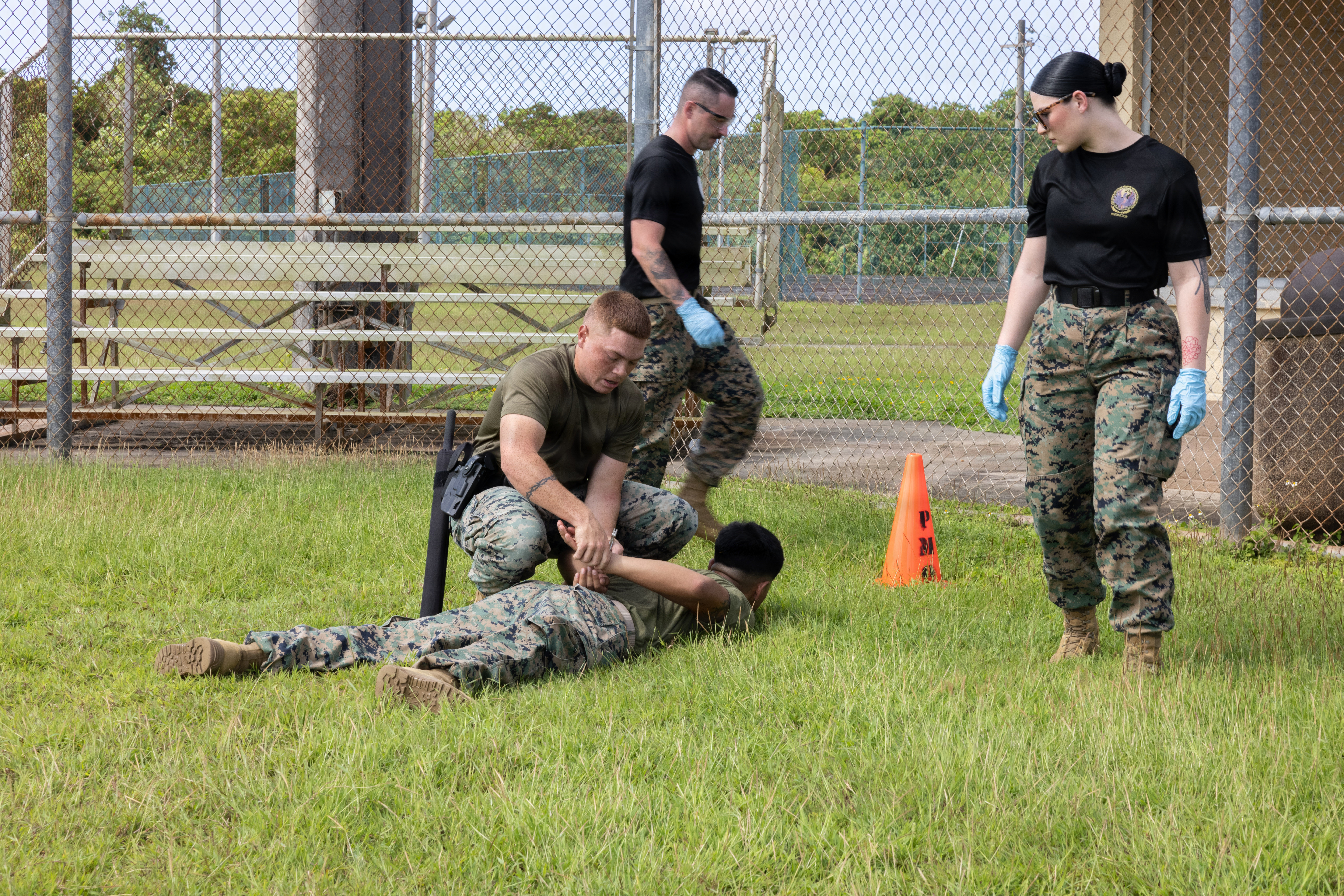 U.S. Marine Corps Lance Cpl. Caleb Roybal, military police officer, Provost Marshal’s Office, Marine Corps Base Camp Blaz, detains a simulated target during an Oleoresin Capsicum Course on MCB Camp Blaz, Guam, Nov. 25, 2025. MCB Camp Blaz military police officers partnered with Guam Police Department officers to conduct an OC spray course. The training is designed to help law enforcement safely employ, endure, and recover from pepper spray exposure while maintaining control of a situation and protecting the public. (U.S. Marine Corps photo by Lance Cpl. Rey Moreno Marilao)