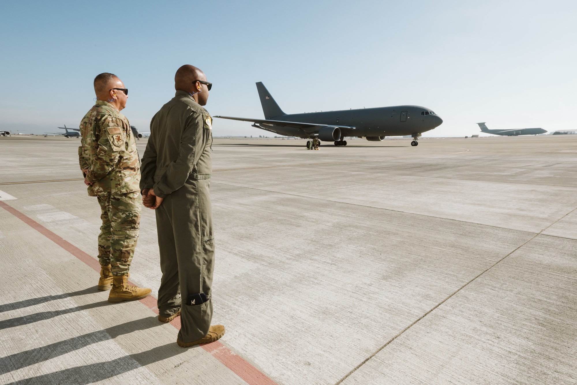 Airmen await aircraft on flight line.