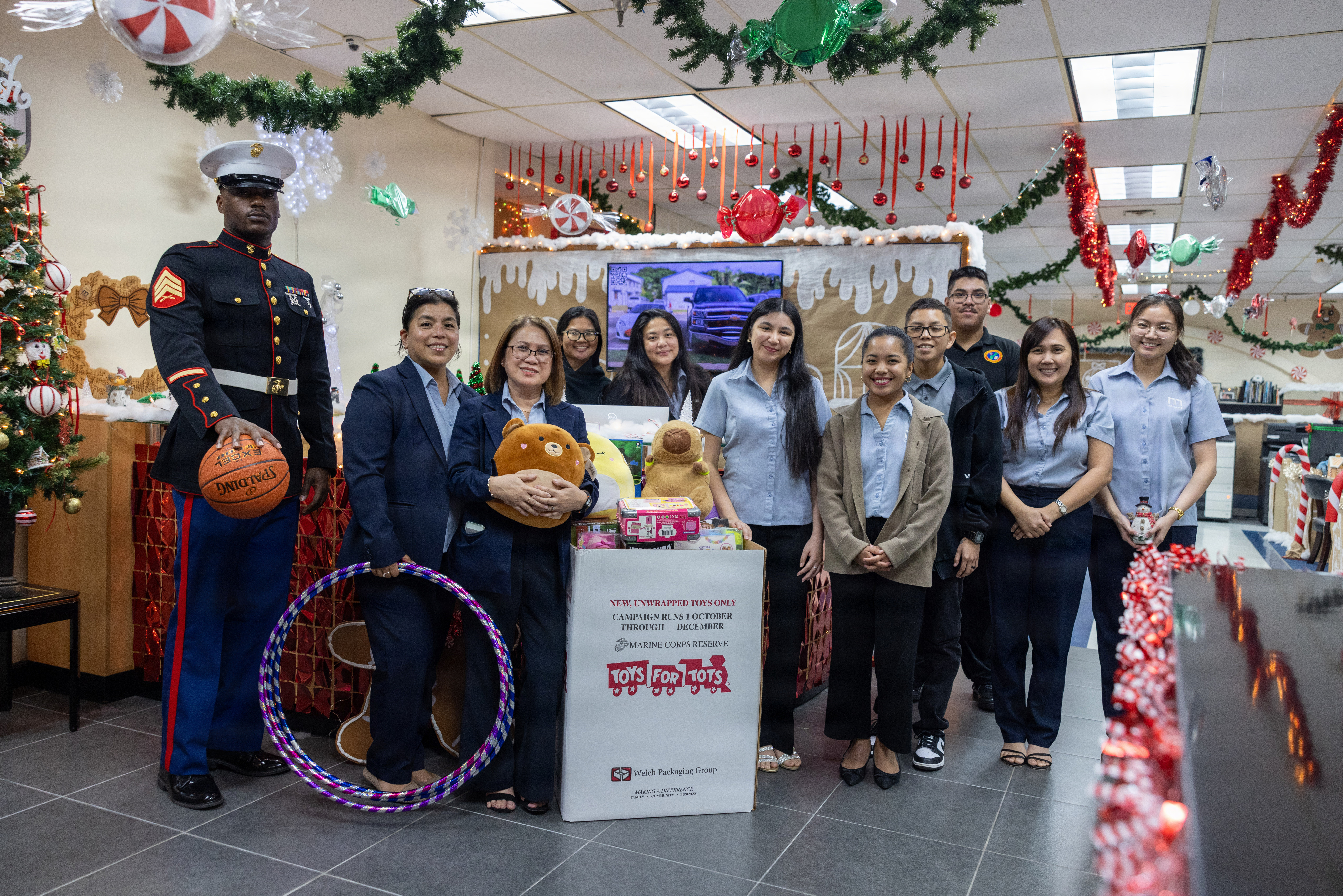 U.S. Marines with Marine Corps Base Camp Blaz pose with the Moylan’s Insurance staff to display the amount of toys being donated for Toys for Tots at the Moylan’s Insurance office, Hagåtña, Guam, Dec. 03, 2025. Toys for Tots was founded in 1947 and has grown into a Marine Corps Reserve nationwide program that brings holiday joy to millions of underprivileged children each year. (U.S. Marine Corps photo by Lance Cpl. Rey Moreno Marilao)